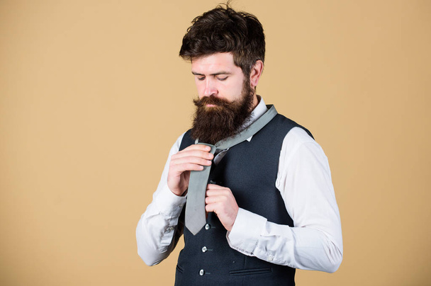 Start with your collar up and the tie around your neck. How to tie simple knot. Art of manliness. Man bearded hipster try to make knot. Different ways of tying necktie knots. How to tie necktie - Foto, Imagem