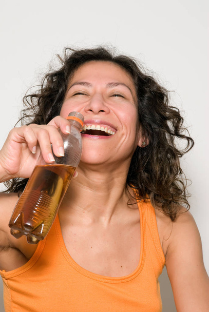 portrait of beautiful woman drinking beverage from plastic bottle - Фото, изображение