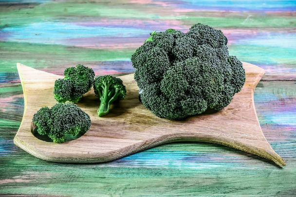 egészséges vagy vegetáriánus étel koncepció. Friss zöld brokkoli fából készült deszkán, rusztikus fa háttérrel. Felülnézet, szöveghely - Fotó, kép
