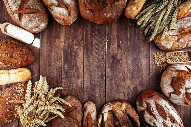 Různé druhy chleba a pečiva se valí na palubě shora. Ki - Fotografie, Obrázek