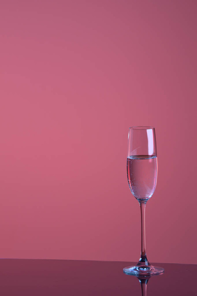 close-up view of glass with transparent liquid on violet background - Fotografie, Obrázek