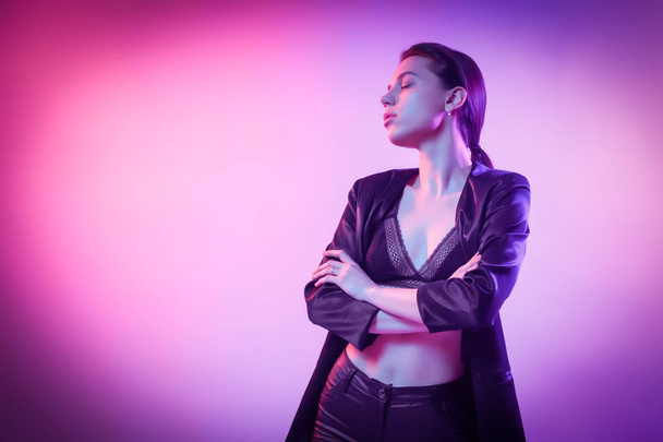 Fashion portrait of young elegant girl in jacket. Colored background, studio shot. Beautiful brunette woman posing. hipster girl in neon.  - Fotoğraf, Görsel