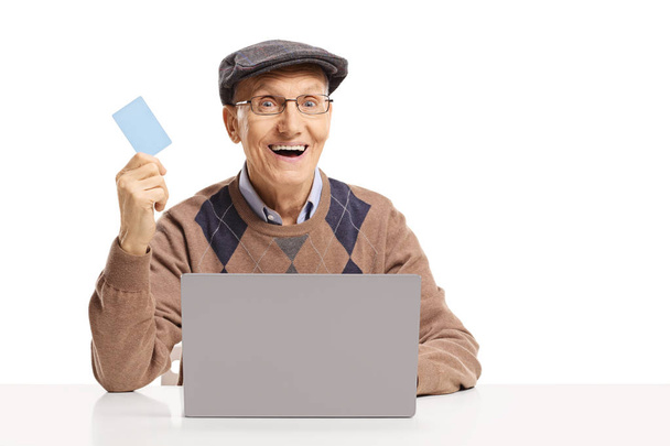 Senior man shopping online with a laptop and a credit card isolated on white background - Valokuva, kuva