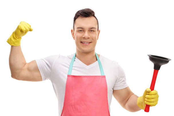 Young man flexing his bicep and holding a plunger isolated on white background - Φωτογραφία, εικόνα