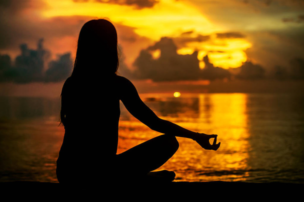 Mulher meditando, relaxando em ioga posar ao pôr do sol, zen meditatio
 - Foto, Imagem