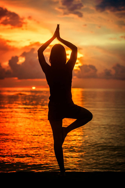 Nainen meditoi, rentoutuu joogassa poseeraa auringonlaskun aikaan, zen meditatio
 - Valokuva, kuva