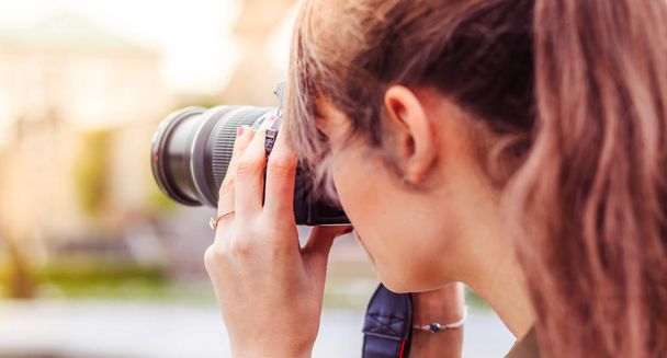 Young female tourist girl is taking shots with her camera - 写真・画像