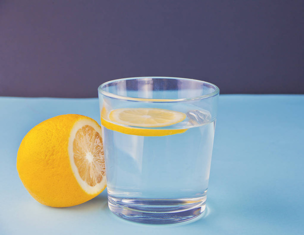 water with lemon on the blue table - 写真・画像