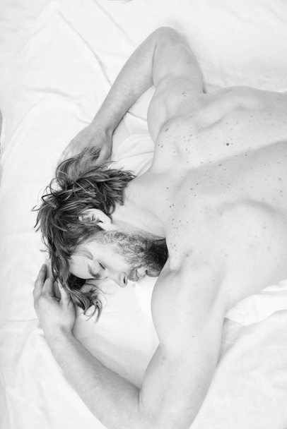 Let your body feel comfortable. Guy nude macho lay white bedclothes. Pleasant relax concept. Make sure mattress comfortable and supportive. Man tired exhausted guy naked back relaxing bed top view - 写真・画像