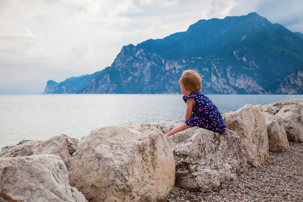 baby girl looking at the Garda lake - Zdjęcie, obraz
