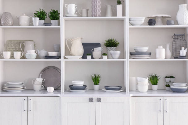 Open cupboard with clean dishes in kitchen - Photo, Image