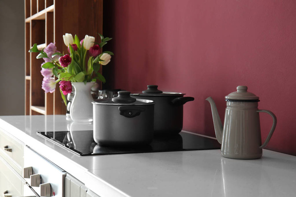 Cacerolas en la cocina eléctrica en la cocina moderna
 - Foto, imagen