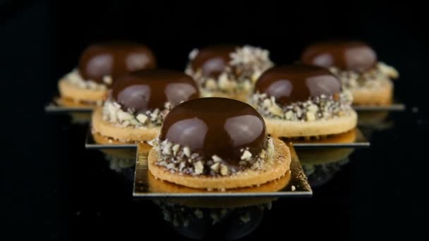 berreg-ban-a készlet-ból francia mini mousse sütemények desszertek borított a csokoládé mázzal, és szolgált a háromszög alakú - Felvétel, videó