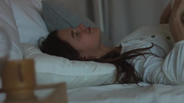 Beautiful girl waking up from pleasant dream stretching in bed in morning natural light 4k. Young woman sleeping lies smiling before getting up to work close up shot. Healthy lifestyle energy relax - Séquence, vidéo