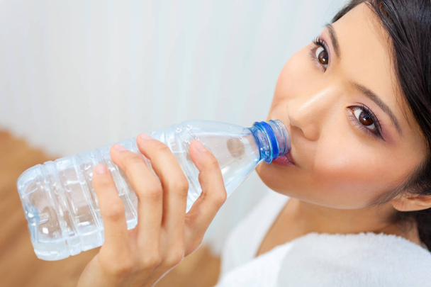 Asian Chinese Girl Drinking Bottle of Water at Gym - Фото, изображение
