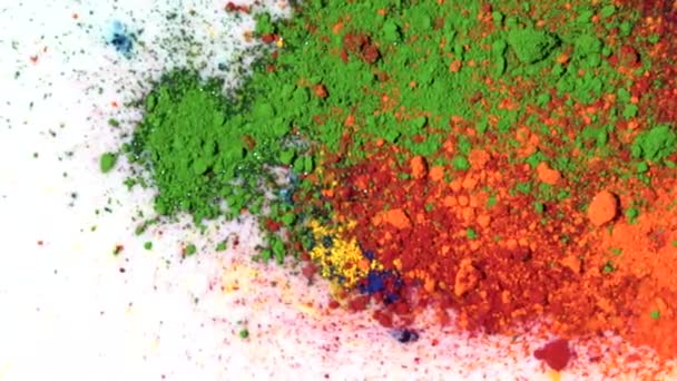 Close-up of crushed pastel. Media. Colorful mixed powder paint on surface of white liquid. Close-up of lumps and particles of colorful mixed paints Holi - Footage, Video