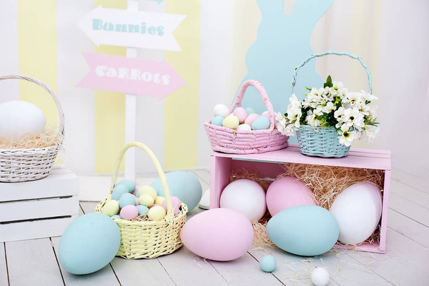 Húsvéti! Sok színes húsvéti tojást nyuszik és kosár virágot! Húsvéti terem dekoráció és dekoráció, gyermek játszószoba. Színes nagy és kis festett húsvéti tojás és színes nyulak. - Fotó, kép