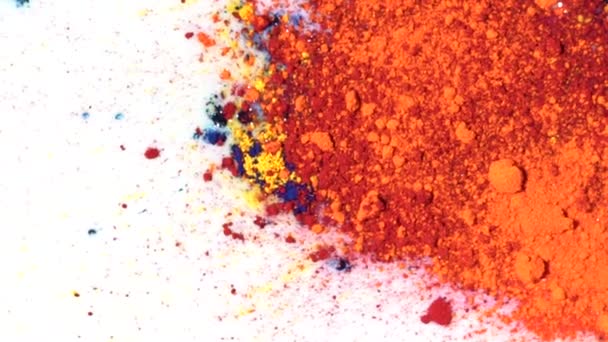 Close-up of crushed pastel. Media. Colorful mixed powder paint on surface of white liquid. Close-up of lumps and particles of colorful mixed paints Holi - Footage, Video