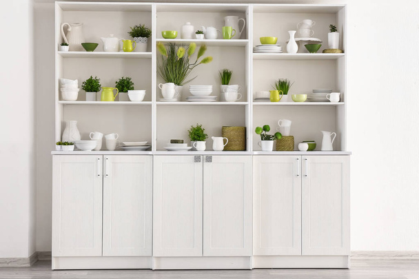 Open cupboard with clean dishes in kitchen - Photo, Image