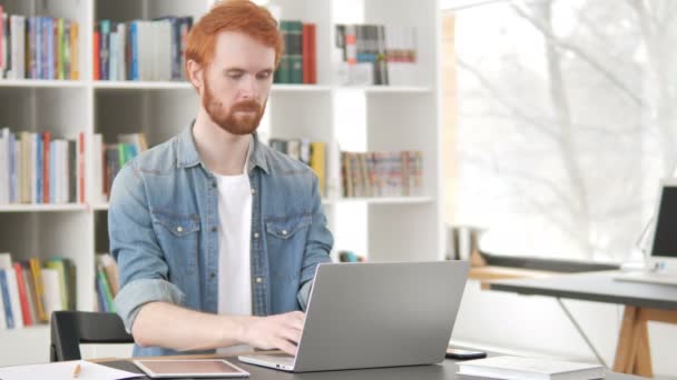 忙しいカジュアルな日常の赤毛の男はノートパソコンで作業 - 映像、動画