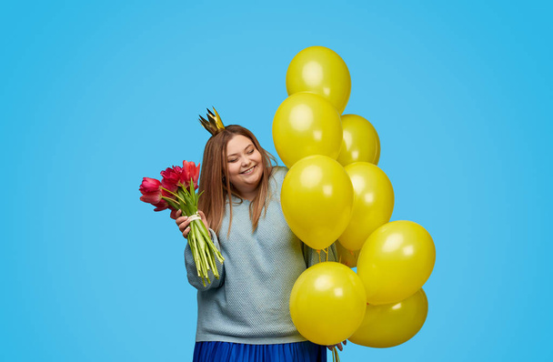 Cheerful plus size woman with flowers and balloons - Фото, зображення