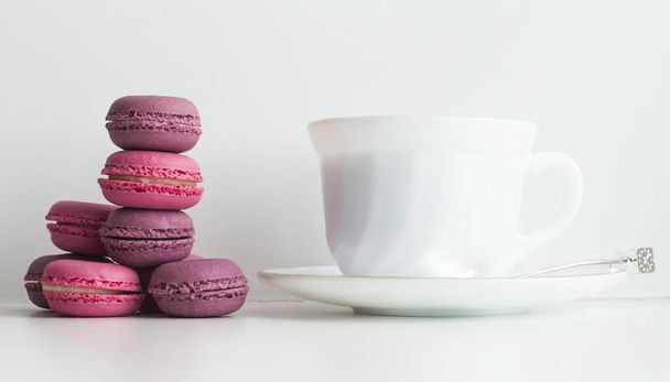 απογευματινό τσάι τραπέζι με πολύχρωμα μακαρόν και ένα φλιτζάνι τσάι - Φωτογραφία, εικόνα