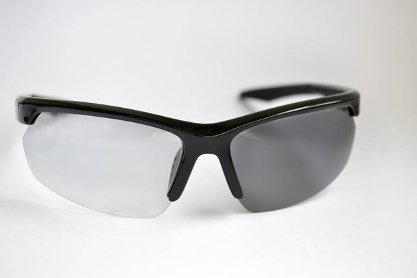 Probando gafas de sol deportivas con efecto fotocrómico, una de las gafas estaba cerrada del sol, y aún transparente
 - Foto, imagen