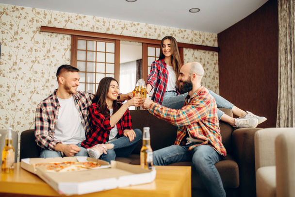 笑顔の友人には、ホーム パーティーでビールをボトルがチャリンという音します。仲が良く、一緒に人々 の余暇のグループ。陽気な会社イベントを祝う - 写真・画像