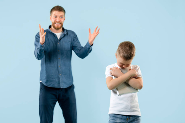Angry father scolding his son in living room at home - Foto, imagen