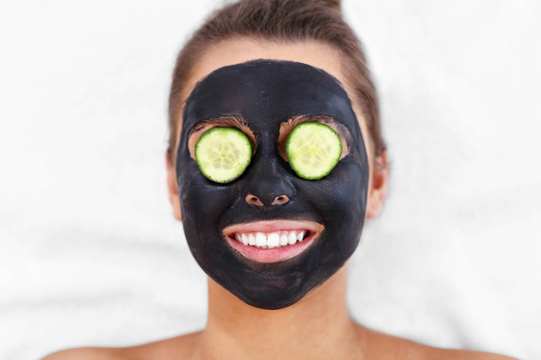 Happy woman having facial in spa salon - Фото, изображение