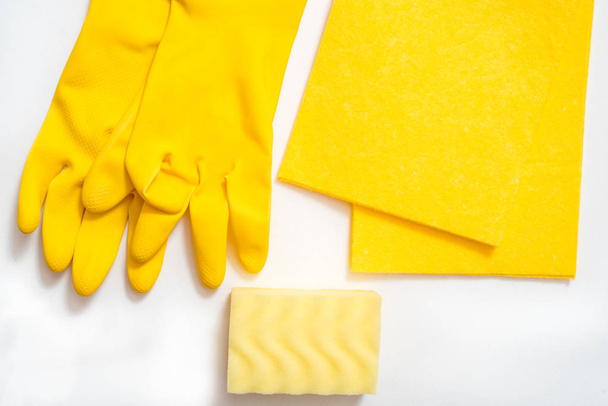 koncepce čištění, na žlutém podkladu růžové rukavice c měkkou kartáčovou lištu, melaminová houbička a sprej na brýle - Fotografie, Obrázek