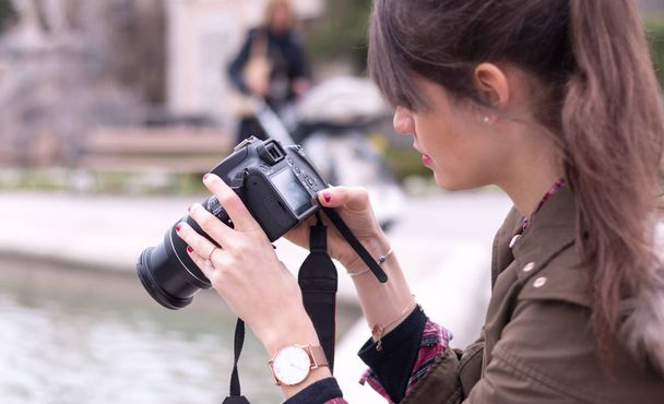 Young female tourist girl is taking shots with her camera - Photo, image