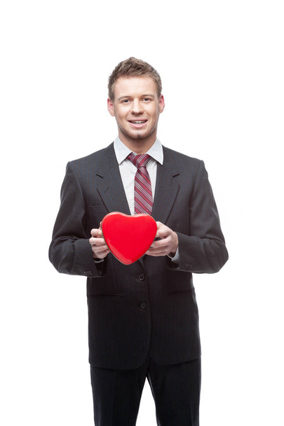 seductive businessman holds and shows  red heart - Φωτογραφία, εικόνα