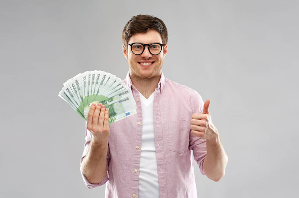 happy young man with euro money showing thumbs up - Fotoğraf, Görsel
