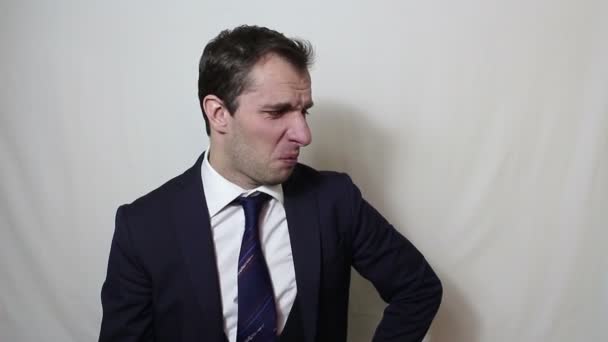 Young handsome businessman actively waving his hand expelling bad smell. - Filmati, video