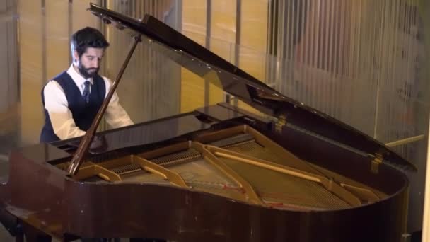Young bearded man playing the piano - Кадри, відео