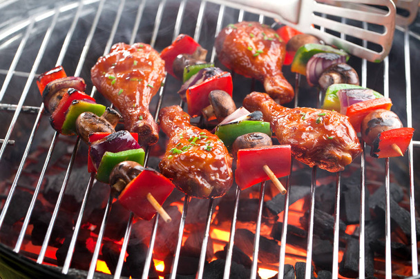 close-up view of delicious chicken meat with vegetables cooking on charcoal grill  - Foto, imagen