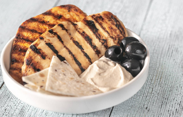 Grilled chicken breast with black olives and tahini sauce - Valokuva, kuva