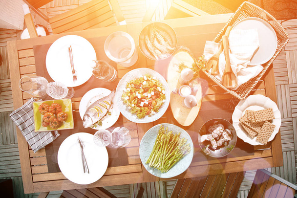 top view of delicious meal with prawns, seafood, salad and vegetables on table, backlit - Fotografie, Obrázek
