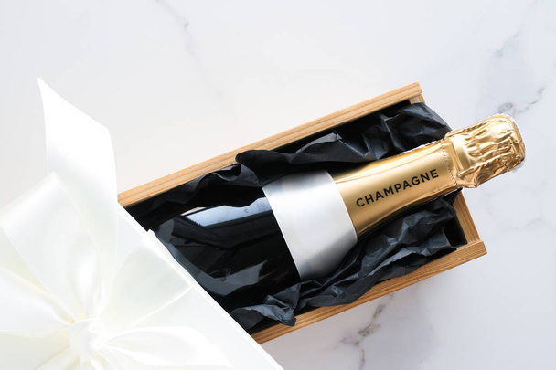 Une bouteille de champagne et une boîte cadeau sur marbre
 - Photo, image