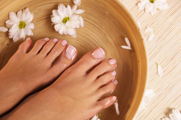 The picture of ideal done manicure and pedicure. Female hands and legs in the spa spot. - Photo, Image