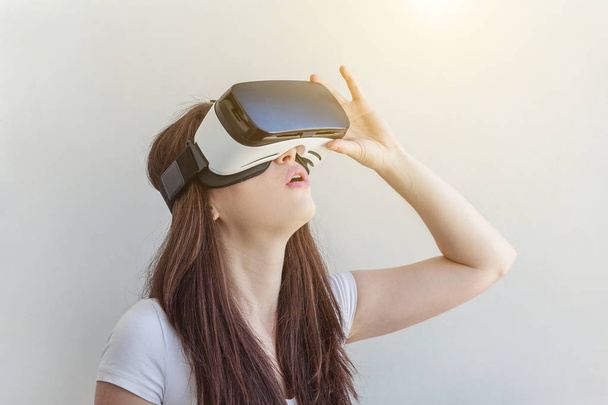 Úsměv mladá žena pomocí virtuální realita Vr brýle přilba Sluchátka na bílém pozadí - Fotografie, Obrázek