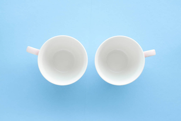 Empty cup and saucer on blue background, flatlay - Photo, Image