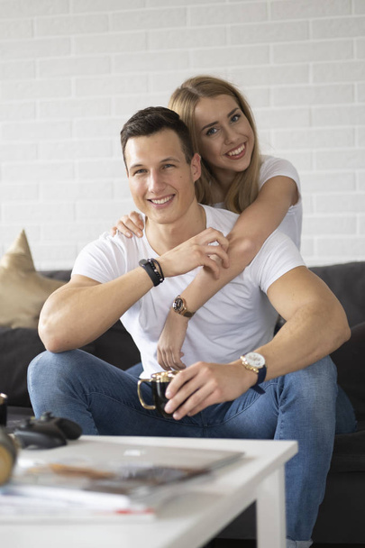 若いカップルは、家庭でコーヒーを飲んで話しながら時間を過ごす. - 写真・画像