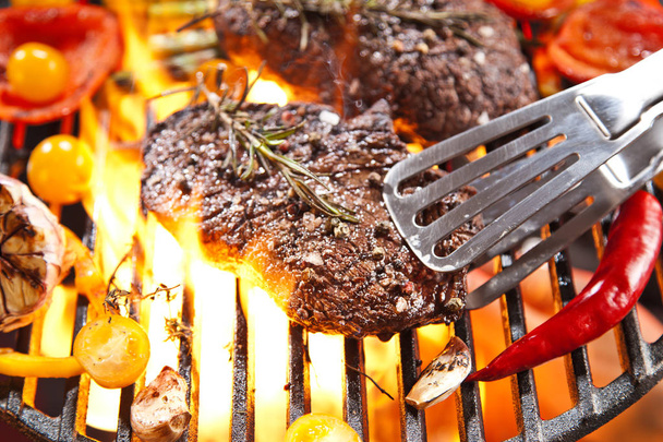 Detailní pohled na vynikající steaky s rozmarýnem, cherry rajčátky a česnekem, vaření na grilu - Fotografie, Obrázek
