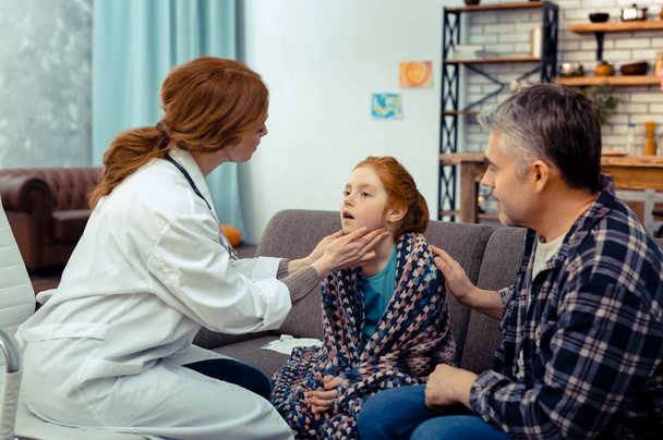 Nice professional doctor touching her patients neck - Valokuva, kuva