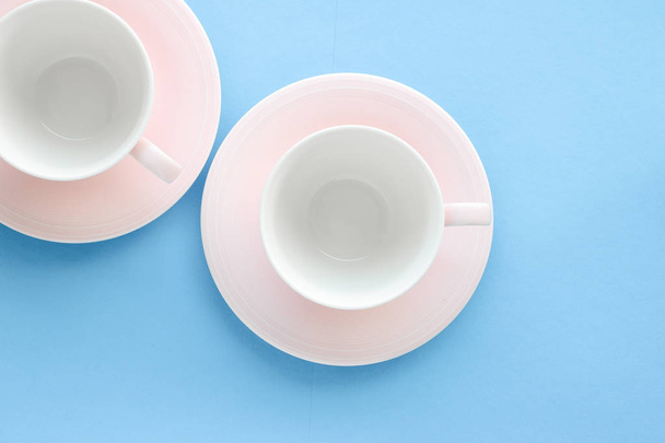 Порожня чашка і блюдце на синьому фоні, плоска
 - Фото, зображення