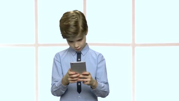 Mały kaukaski chłopiec za pomocą smartfona. - Materiał filmowy, wideo