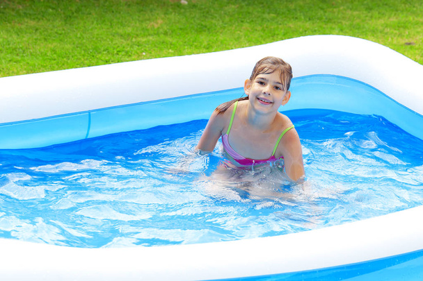 adorable adolescente chica jugando en piscina en verano
  - Foto, Imagen