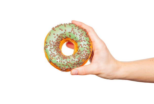 Female hand holding colorful donut on pastel white background - Foto, immagini